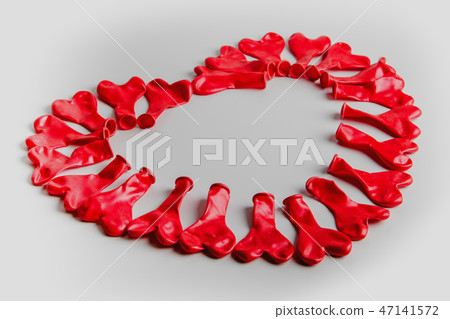 deflated balloons in the shape of a heart 47141572