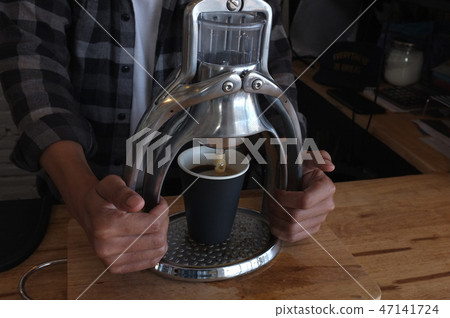 Barista grinding coffee beans Barista grinding coffee beans 47141724