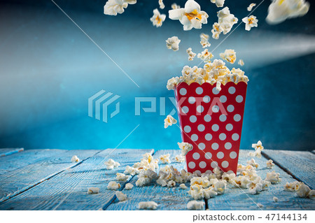 Box of popcorn on blue background. 47144134