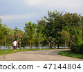 Back view of man running outdoor in park with lake 47144804