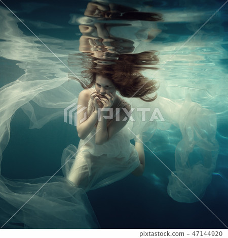 Portrait of a girl in a white dress under water Portrait of a girl in a white dress under water 47144920