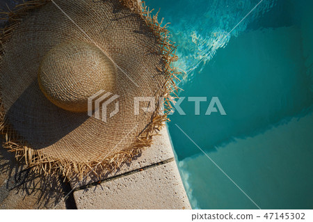 sun hat on the edge of the pool. summer background 47145302