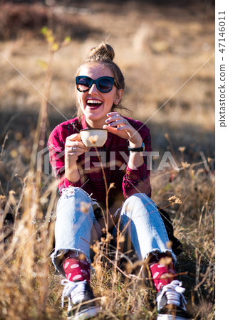 Woman having a cup of coffee outdoors Woman having a cup of coffee outdoors 47146011