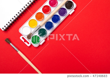 Watercolor paints and brushes with canvas for painting with copyspace on red background Watercolor paints and brushes with canvas for painting with copyspace on red background 47148683