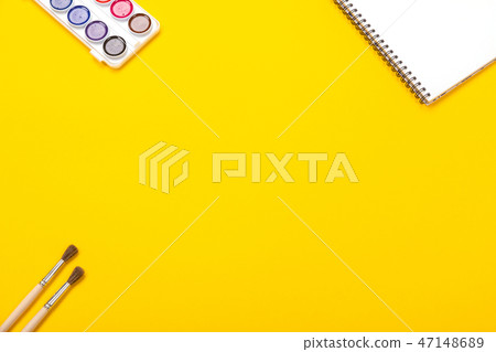 Watercolor paints and brushes with canvas for painting with copyspace on yellow background Watercolor paints and brushes with canvas for painting with copyspace on yellow background 47148689