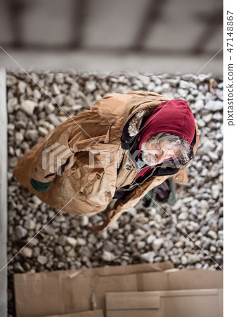 A top view of homeless beggar man standing outdoors in city. A top view of homeless beggar man standing outdoors in city. 47148867