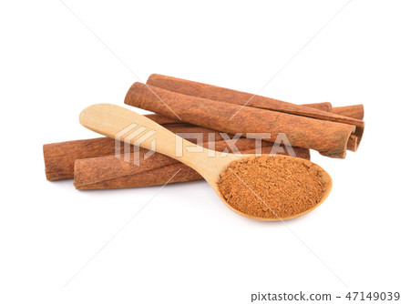 dried ground cinnamon in spoon and cinnamon stick 47149039