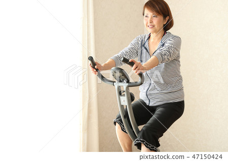 與健身自行車的婦女訓練 與健身自行車的婦女訓練 47150424