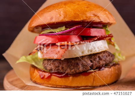 Burger with bacon, cheese and vegetables Burger with bacon, cheese and vegetables 47151027