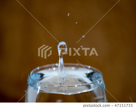 The form of a drop falling into a cup of water 47151733