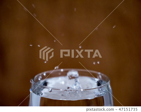 The form of a drop falling into a cup of water 47151735
