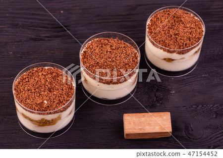 Tiramisu with a chocolate crumb in plastic cups Tiramisu with a chocolate crumb in plastic cups 47154452