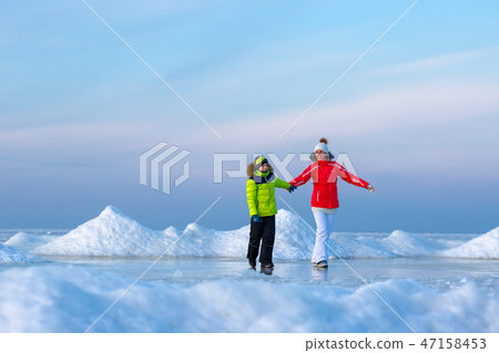Young mother and her son on icy beach Young mother and her son on icy beach 47158453