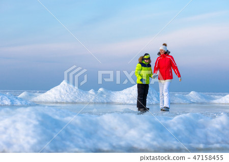 Young mother and her son on icy beach Young mother and her son on icy beach 47158455