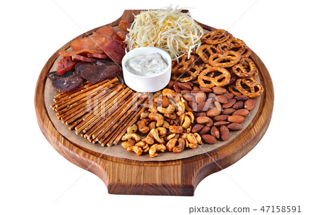 Mix of beer snacks on round wooden board Mix of beer snacks on round wooden board 47158591