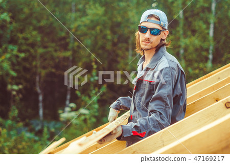 the worker is building the roof 47169217
