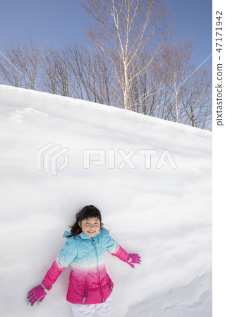 Primary school girl with snow wall Primary school girl with snow wall 47171942
