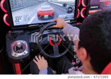 Boy enjoying car racing game in game center Boy enjoying car racing game in game center 47171993
