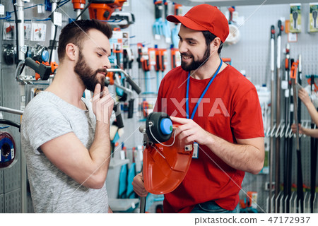 Salesman is showing bearded client new lawn mower  47172937