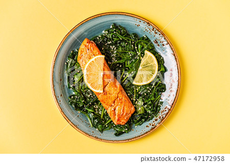 Grilled salmon with spinach. 47172958
