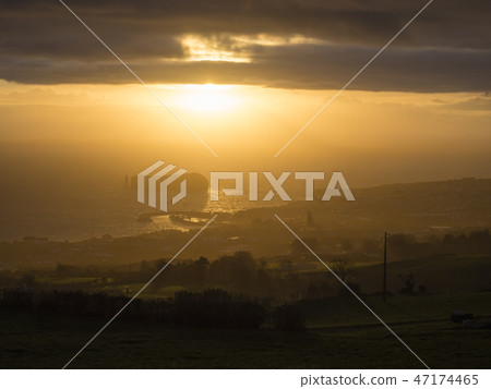 Aerial view of Vila Franca do Campo town volcanic islet during orange sunset with clouds, contre 47174465
