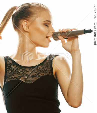 young pretty blond woman singing in microphone isolated close up 47176262