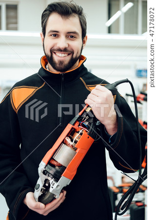 Salesman is posing with new disc grinder in power  47178072