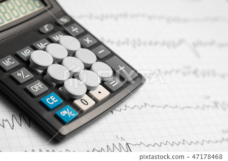 Tablets are on the calculator on background of electrocardiogram Tablets are on the calculator on background of electrocardiogram 47178468