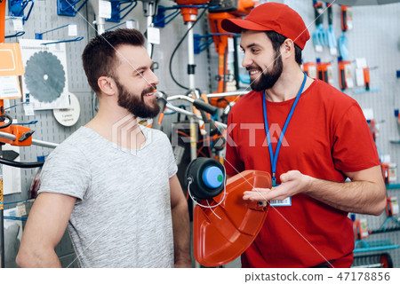 Salesman is showing bearded client new lawn mower  47178856