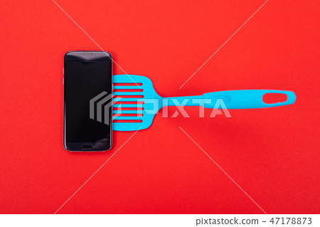 Top view of smart phone as part of cooking equipment in kitchen isolated on red background Top view of smart phone as part of cooking equipment in kitchen isolated on red background 47178873