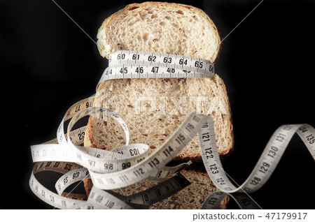 slice of bread surrounded by a measurement tape slice of bread surrounded by a measurement tape 47179917