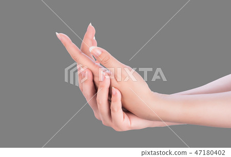 女人的手塗抹牛奶霜治療灰色皮膚灰色背景 女人的手塗抹牛奶霜治療灰色皮膚灰色背景 47180402