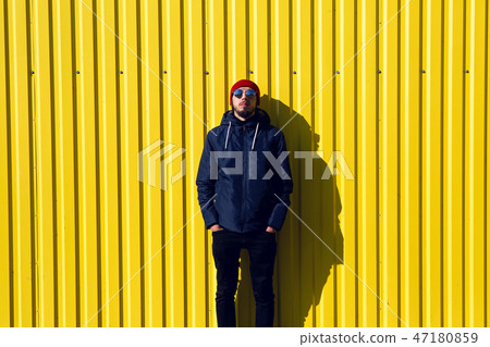 guy in the red hat stands at the wall of the iron house in nature guy in the red hat stands at the wall of the iron house in nature 47180859