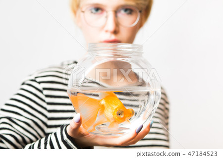 Portrait of a beautiful girl with a goldfish in an aquarium. Portrait of a beautiful girl with a goldfish in an aquarium. 47184523