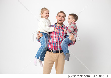 Father with children having fun on a white background. Father holds daughter and son. 47184581