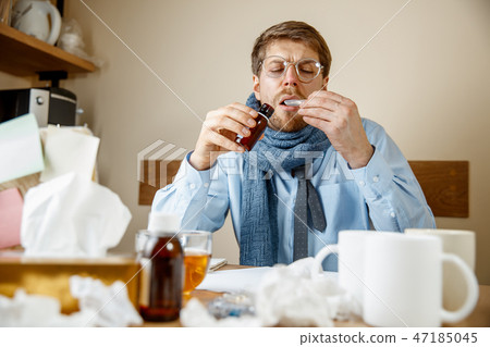 Sick man while working in office, businessman caught cold, seasonal flu. Sick man while working in office, businessman caught cold, seasonal flu. 47185045