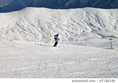 Skier downhill on snowy ski slope in sun winter Skier downhill on snowy ski slope in sun winter 47186198