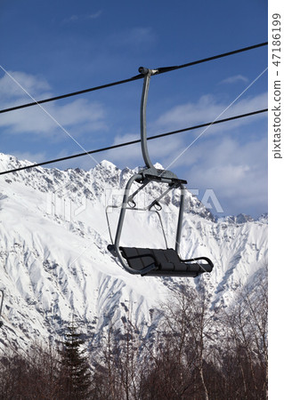 Ski-lift on ski resort and snowy mountains Ski-lift on ski resort and snowy mountains 47186199