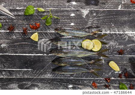 Row of fish on black wooden background 47186644