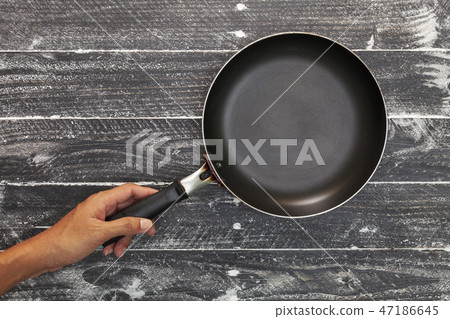 hand holding empty kitchen frying pan  47186645