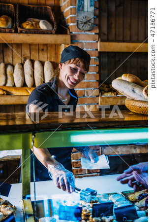 Female Bakery Assistant Working At Bakery Shop Female Bakery Assistant Working At Bakery Shop 47186771
