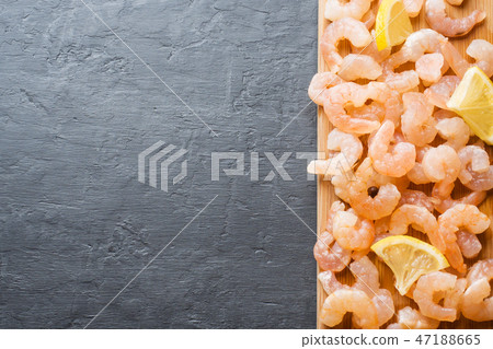 Shrimp with spices and lemon on a wooden Board.  47188665