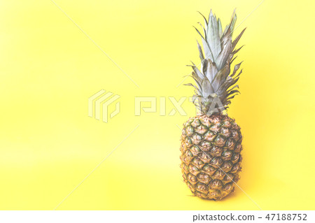 Ripe pineapple on a yellow toned background Ripe pineapple on a yellow toned background 47188752
