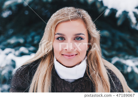 Winter young woman portrait. Beauty Joyful Model Girl laughing and having fun in winter park Winter young woman portrait. Beauty Joyful Model Girl laughing and having fun in winter park 47189067
