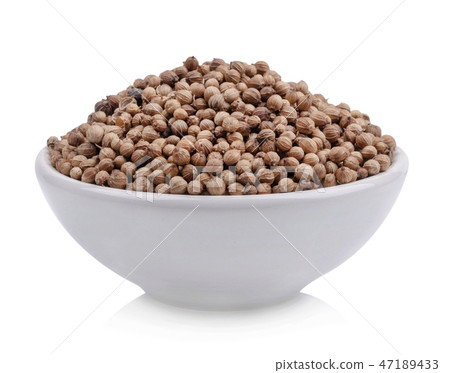 Coriander seeds in a cup of white background Coriander seeds in a cup of white background 47189433