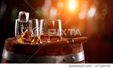 Whiskey drinks with flying ice rocks 47189439