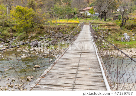 wooden suspension bridge over a river  47189797