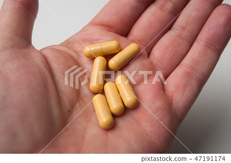 yellow drug capsules in hand of man yellow drug capsules in hand of man 47191174