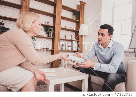 Serious young therapist demonstrating her psychological book Serious young therapist demonstrating her psychological book 47192755