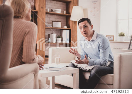 Worried brunette male person talking to his therapist Worried brunette male person talking to his therapist 47192813